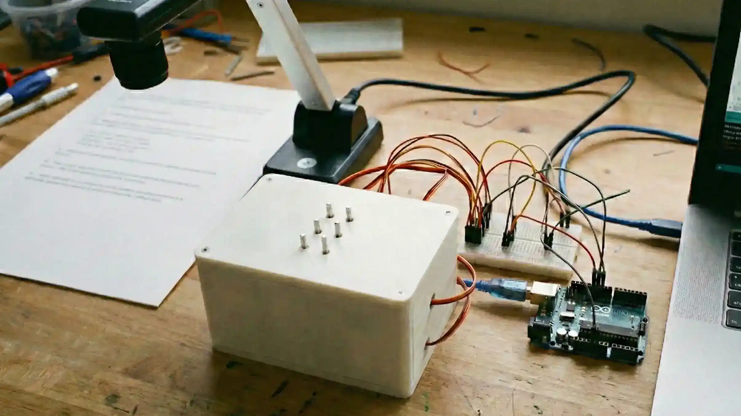 Hardware setup for the Audio Mate project, featuring a webcam and an Arduino-driven robotic Braille display.